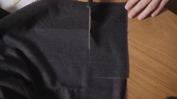 Bovenaanzicht. Snijden donkere wol stof. het lijnpatroon. Jonge man werken als een kleermaker en een naaimachine gebruiken in werkplaats. — Stockvideo