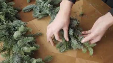 El portre. İş yerinde çiçekçi: kadın el Noel süslemeleri çelenk köknar Nobilis yapma. Mutlu yeni yıl akşam yemeği bayram