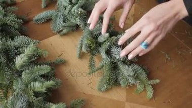 El portre. İş yerinde çiçekçi: kadın el Noel süslemeleri çelenk köknar Nobilis yapma. Mutlu yeni yıl akşam yemeği bayram