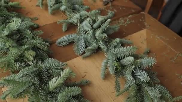 Bloemist op het werk: vrouw handen maken Kerst decoraties garland van Spar Nobilis. Gelukkig Nieuwjaar diner feest — Stockvideo