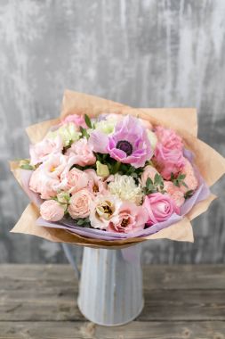 Vazoda karışık çiçeklerden oluşan güzel bir buket. Çiçekçi dükkanındaki çiçekçinin işi. Boşluğu kopyala