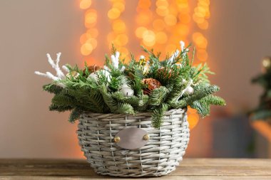 Bir hasır sepet ahşap kurullarında güzel Noel kompozisyon. Tatil kavramı için hazırlık. Çiçekçi dükkanı profesyonel çiçekçi ana bir eseridir. kopya alanı. Işıklar garland