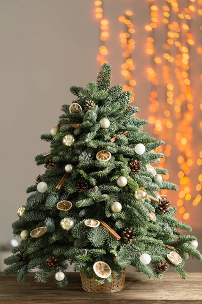 Bellissimo albero di Natale su tavole di legno. Preparazione per il concetto di vacanza. Negozio di fiori è un capolavoro di un fiorista professionista. copiare spazio. ghirlanda luci — Foto Stock