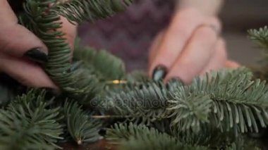 El portre. İş yerinde çiçekçi: kadın el Noel süslemeleri çelenk köknar Nobilis yapma. Mutlu yeni yıl akşam yemeği bayram