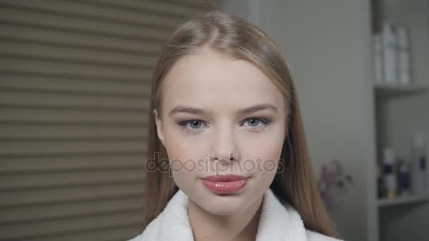 Retrato de mujer atractiva sonriente rubia. En un albornoz blanco después del procedimiento. Concepto de centro de Cosmetología y SPA . — Vídeos de Stock