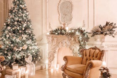 Noel akşam mum ışığında. Klasik dairelerde beyaz bir şömine, dekore edilmiş ağaç, kanepe, büyük pencereler ve avize.