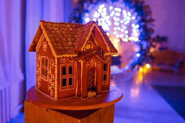 Gingerbread house. European Christmas holiday traditions. Garland blue lights on background. Xmas holiday sweets