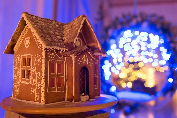 Gingerbread house. European Christmas holiday traditions. Garland blue lights on background. Xmas holiday sweets