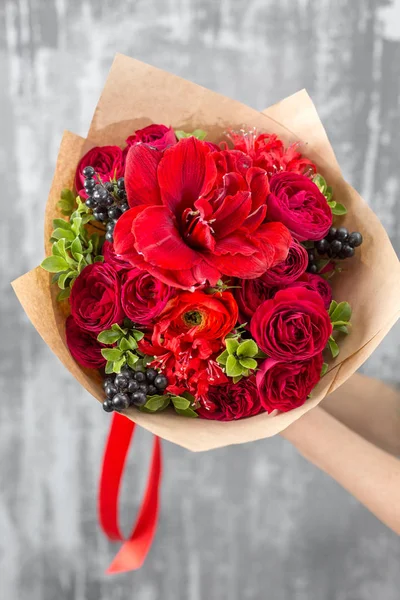 Belo buquê de luxo de flores mistas na mão da mulher. o trabalho da florista em uma loja de flores. Cor vermelha — Fotografia de Stock