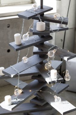Alternatif ahşap Noel ağacı. Bir el yapımı yılbaşı ağacı ve ampul odasında yerde