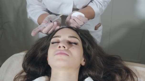 Una mujer guapa recibe una inyección en la cabeza. El procedimiento hace médico en guantes blancos. El concepto de mesoterapia. Empuje para fortalecer el cabello y su crecimiento — Vídeos de Stock