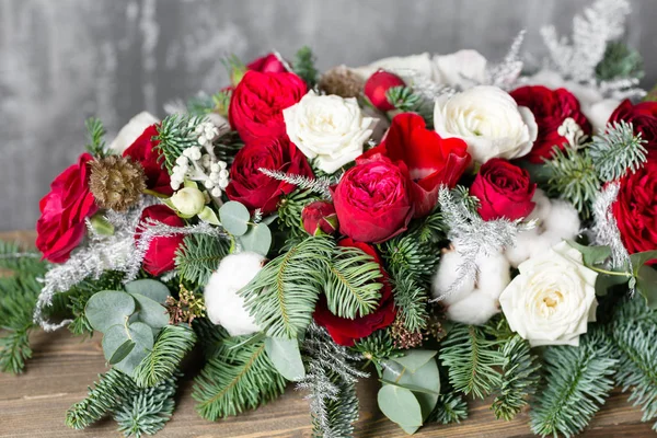 Winter decor. The composition of the branches Nobilis and fresh flowers. Work florist in shop. For decorating a family dinner — Stock Photo, Image