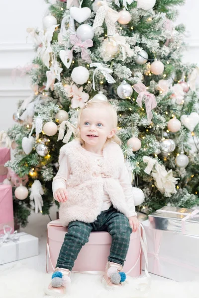 Portrait beautiful little girl Christmas tree in the background. light bulbs garlands — Stock Photo, Image