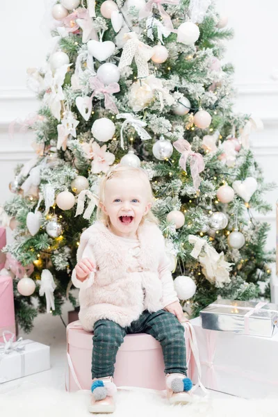 Portrét krásné děvčátko vánoční strom v pozadí. žárovky girlandy — Stock fotografie