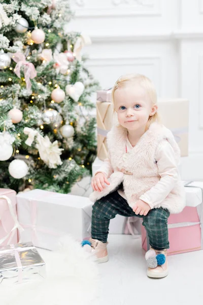 Portrait beautiful little girl Christmas tree in the background. light bulbs garlands — Stock Photo, Image