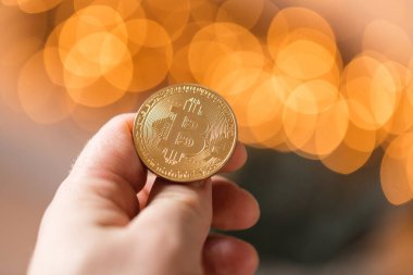 Adam tutarak altın bitcoin. Bokeh ışıklar üzerinde arka plan bulanık. cryptocurrency kavramı