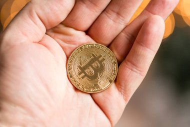 Adam tutarak altın bitcoin. Bokeh ışıklar üzerinde arka plan bulanık. cryptocurrency kavramı