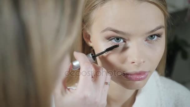 Mascara occhi di vernice. Truccatore creando bel trucco per il modello bionde. Beauty and Spa concetto di centro — Video Stock