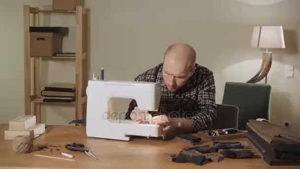 Hace pajaritas. Joven trabajando como sastre y utilizando una máquina de coser en un estudio textil . — Vídeo de stock