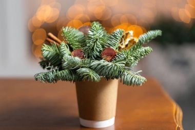 Tekne ahşap bir masa üzerinde kahve bardakları kağıt. Noel süsleri çam ağacı ile kahve kavramı. Arka plan bokeh ampul garland üzerinde