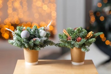 İki tekne ahşap bir masa üzerinde kahve bardakları kağıt. Noel süsleri çam ağacı ile kahve kavramı. Arka plan bokeh ampul garland üzerinde