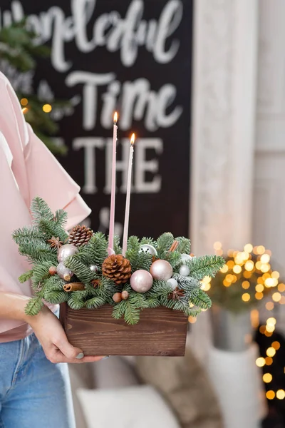 Acender velas. Oficina de decoração de Natal com suas próprias mãos. Caixa de madeira de Natal com ramos de abeto para o feriado. A celebração do ano novo . — Fotografia de Stock