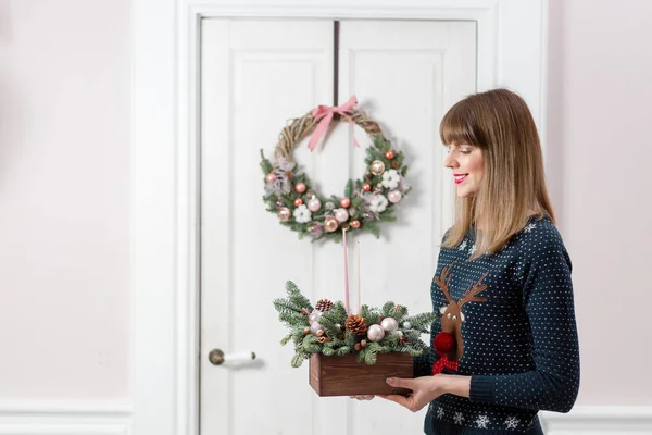 Jonge vrouw met een houten doos van Kerstmis met spar takken voor de vakantie. De nieuwe jaarviering. — Stockfoto