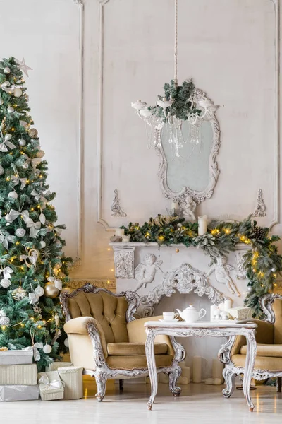 Mañana de Navidad. apartamentos clásicos con chimenea blanca, abeto decorado, sofá, grandes ventanales y lámpara de araña . —  Fotos de Stock