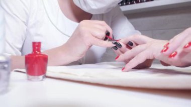 Manikür. Manikür şişe ön plan üzerinde bir eğim alarak. Master vernik çivi jeli Spa çizim geçerlidir. Closeup parmak tırnak bakım Güzellik Salonu uzmanı tarafından.