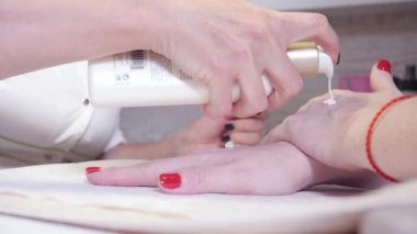 Nemlendirici krem eller. Manikür. Closeup parmak tırnak bakım Güzellik Salonu uzmanı tarafından.