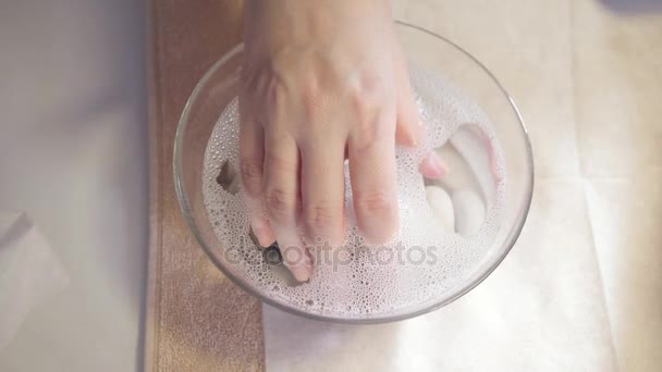 Procedimiento de hidratación de uñas, la mano yacía en el baño con agua. Primer plano. Salón de belleza manicura. manicura hace el procedimiento para el cuidado de las uñas — Vídeo de stock