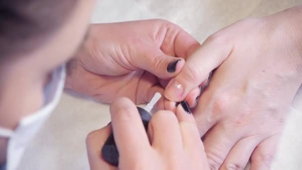 Maniküre. Meister trägt Lackzeichnung auf Nagelgel im Spa auf. Nahaufnahme Fingernagelpflege durch Spezialisten im Schönheitssalon. — Stockvideo