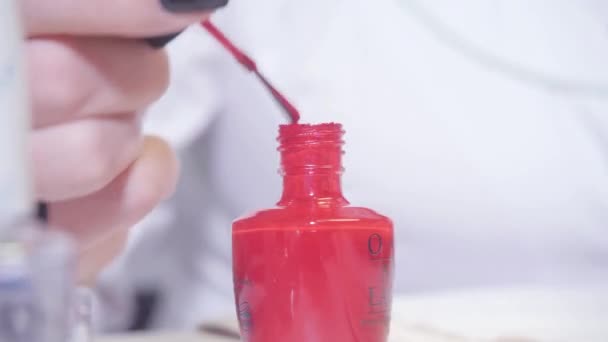 Manicure. Het nemen van een duik van manicure fles op de voorgrond. Master geldt vernis puttend uit gel van de nagels in spa. Closeup vinger nail care door specialist in beautysalon. — Stockvideo