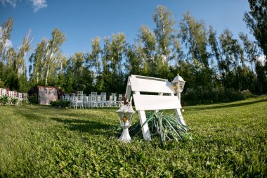 Güzel ayarı açık havada düğün gelin ve damat ve Konuklar için bekliyor. Çiçekleri ile süslenmiş beyaz sandalye bölgeyi ormandaki düğün töreni vardır. kopya alanı