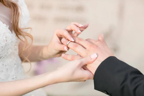 Alianças de casamento e mãos de noiva e noivo. jovem casal de casamento na cerimônia. matrimónio. homem e mulher apaixonados. duas pessoas felizes celebrando tornar-se família — Fotografia de Stock