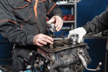 Tamirci yeni bir piston yükler. Motor bloğu araç sökmeye. Motor sermaye onarım. 16 valf ve dört silindirli. Araba hizmet anlayışı.