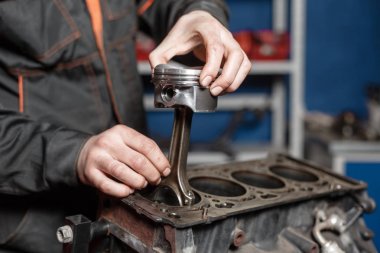 Tamirci yeni bir piston yükler. Motor bloğu araç sökmeye. Motor sermaye onarım. 16 valf ve dört silindirli. Araba hizmet anlayışı.