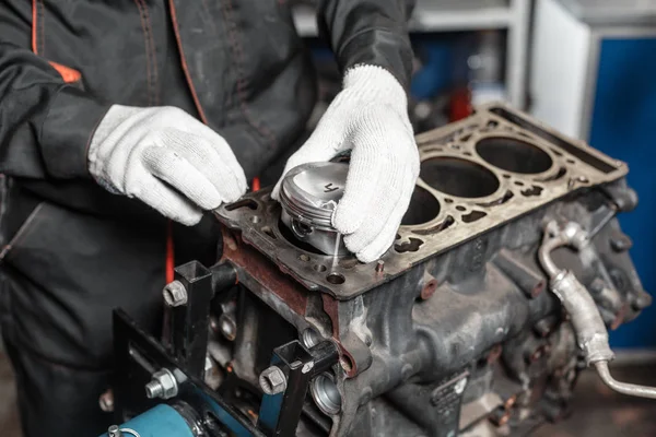 El mecánico instala un nuevo pistón. Desmonte el vehículo del bloque del motor. Reparación de capital motor. 16 válvulas y 4 cilindros. Concepto de servicio de coche . —  Fotos de Stock