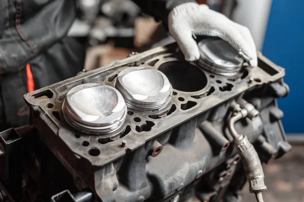 O mecânico instala um novo pistão. Desmontar o veículo de bloco do motor. Reparação de capital automóvel. 16 válvulas e quatro cilindros. Conceito de serviço de carro . — Fotografia de Stock