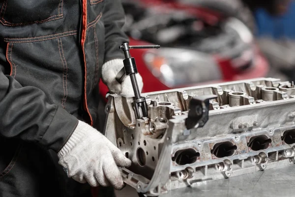 Mekanikern öppnas ventilen låsmekanismen. Demontera motorblocket fordon. Motor kapital reparation. Sexton ventiler och fyra cylinder. Bil servicekoncept. — Stockfoto