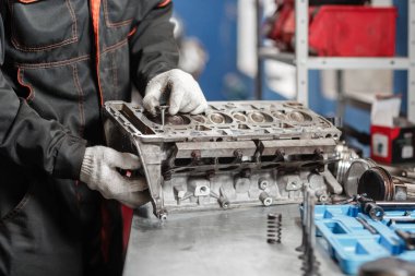 Tamirci yeni bir vana yükler. Motor bloğu araç sökmeye. Motor sermaye onarım. 16 valf ve dört silindirli. Araba hizmet anlayışı.