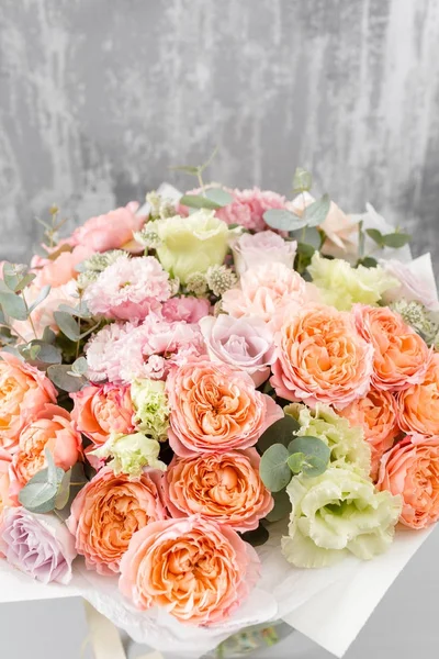 Beau bouquet de fleurs mélangées dans un vase sur table en bois. le travail du fleuriste dans un magasin de fleurs — Photo