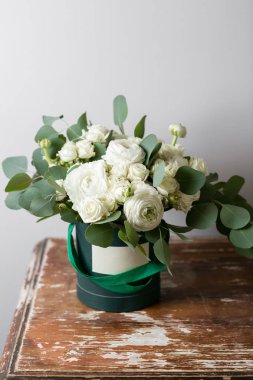 Karışık beyaz çiçekli. Sprey gül ve ranunculuses ahşap masa bir kutusunda buket. kopya alanı. boş metin için