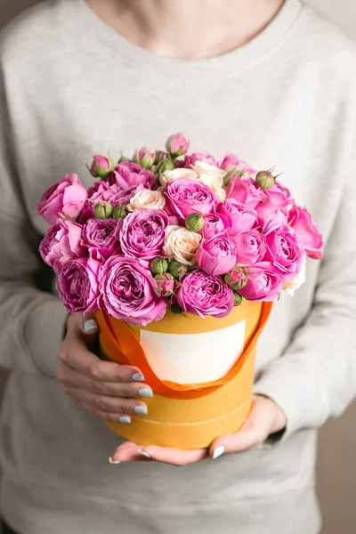 Primer plano de la caja con rosas rociadas de color rosa en manos femeninas. espacio de copia. en blanco para texto — Foto de Stock