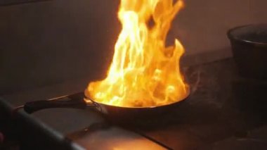 Ateşle tavada pişirme. tavuk göğsü. Bir ticari mutfak pişirme profesyonel şef. Mutfakta hob üzerinde tavada kızartma yemek dostum. ağır çekim