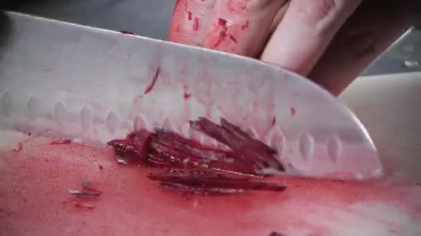 Närbild av hand med kniv skära färska grönsaker. Unga kocken skärande betor på en vit cutting board närbild. Matlagning i ett restaurangkök — Stockvideo