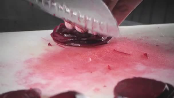 Close-up van de hand met mes snijden verse groente. Jonge chef-kok snijden bieten op een witte cutting board close-up. Koken in de keuken van een restaurant — Stockvideo