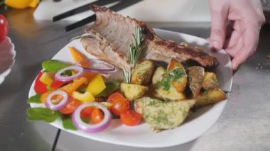 Şef restoranda hazırlar. Taze sebze ve patates kızartması ile kuzu ızgara raf