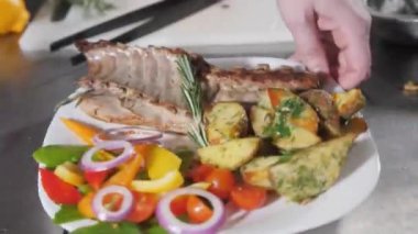 Şef restoranda hazırlar. Taze sebze ve patates kızartması ile kuzu ızgara raf