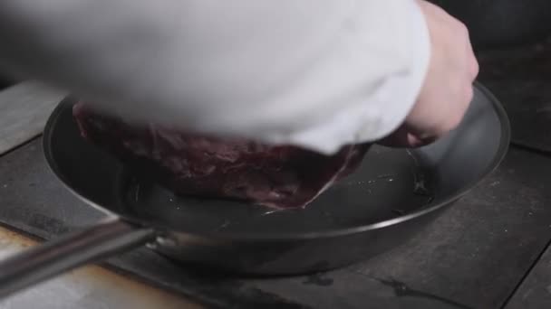 Costelas fritas de cordeiro. Cozinhar com fogo na frigideira. Chef profissional em uma cozinha de cozinha de restaurante. Homem fritando comida em panela flamejante na fogão . — Vídeo de Stock